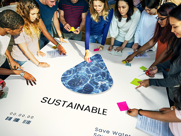 kids looking at a chart of water across a table that says sustainable