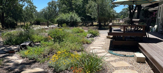 A fire-wise landscape with a deck and pavers closest to the house, then low water plants.