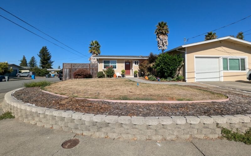 Brown lawn shown in front corner home lot before it was converted to water-wise landscape